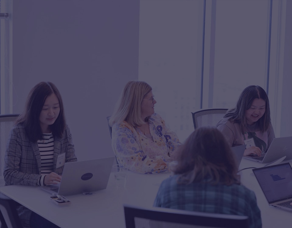 Group of women meeting in a glass-walled conference room