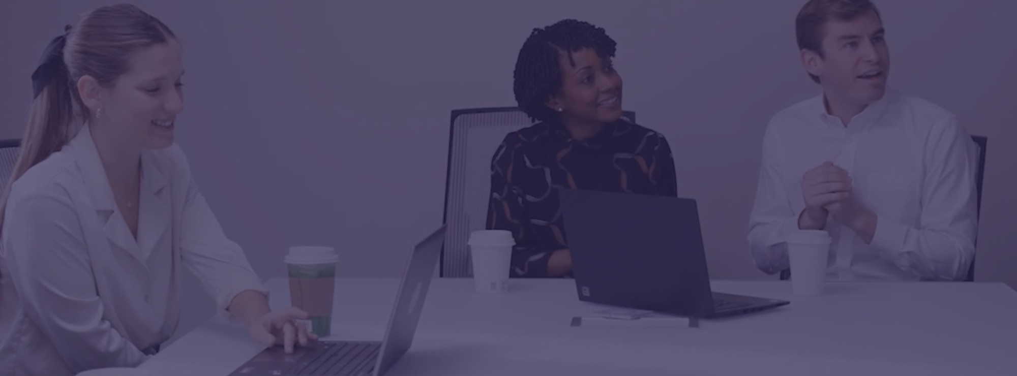 Three people sitting in a conference room