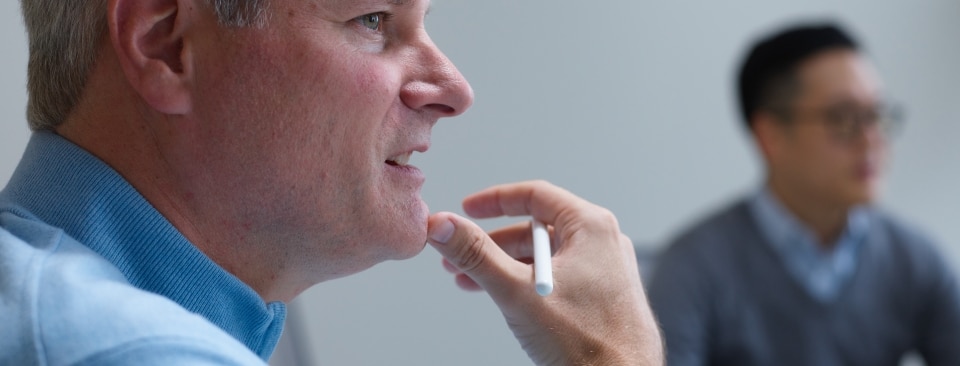 A colleague listening to someone chat in a meeting